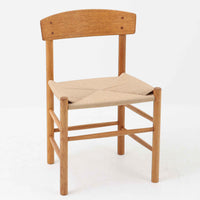 デンマークを代表するデザイナー、Borge MogensenによってFDBのためにデザインされたJ39チェアは、オーク材の丸脚と座面に丁寧に編み込まれたペーパーコードが特徴の、素朴ながらも完成度の高い北欧ビンテージチェアです。農村のキッチンチェアをルーツに持つそのデザインは、無駄を省いた潔い構造と機能美が融合し、空間に凛とした佇まいをもたらします。ダイニングはもちろん、ワークチェアやアクセントチェアとしても重宝する一脚です。