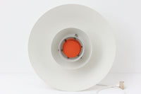 北欧照明の巨匠Poul Henningsenによってデザインされた「PH4」ペンダントライト。Louis Poulsen社製で、光を効率よく拡散させる3枚シェード構造が特徴。内側にオレンジのリフレクターを備えており、暖かく落ち着いた光を演出します。シェード表面には経年に伴う擦れや細かい傷、塗装の薄れが見られますが、ビンテージらしい味わいを感じられる一品です。リビングやダイニング、カウンター上などにおすすめのサイズ感です。