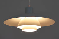 北欧照明の巨匠Poul Henningsenによってデザインされた「PH4」ペンダントライト。Louis Poulsen社製で、光を効率よく拡散させる3枚シェード構造が特徴。内側にオレンジのリフレクターを備えており、暖かく落ち着いた光を演出します。シェード表面には経年に伴う擦れや細かい傷、塗装の薄れが見られますが、ビンテージらしい味わいを感じられる一品です。リビングやダイニング、カウンター上などにおすすめのサイズ感です。