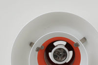 北欧照明の巨匠Poul Henningsenによってデザインされた「PH4」ペンダントライト。Louis Poulsen社製で、光を効率よく拡散させる3枚シェード構造が特徴。内側にオレンジのリフレクターを備えており、暖かく落ち着いた光を演出します。シェード表面には経年に伴う擦れや細かい傷、塗装の薄れが見られますが、ビンテージらしい味わいを感じられる一品です。リビングやダイニング、カウンター上などにおすすめのサイズ感です。