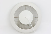 デンマークを代表する建築家・デザイナー、アルネ・ヤコブセンによってデザインされた「AJロイヤル」ペンダントライト。Louis Poulsen(ルイスポールセン)社より発表され、建築物と調和するミニマルなフォルムが特徴的です。こちらは直径50cmのホワイトカラーのモデルで、1958年に設計されたコペンハーゲンのSASロイヤルホテルのために開発されたシリーズのひとつ。上部のルーバー構造からも光が漏れる設計により、下方向だけでなく柔らかく空間全体を照らします。モダニズムの美学が息づく名作照明でありながら、日常の空間にもすっと馴染む柔らかな存在感が魅力です。ヴィンテージ品のため、シェードには擦り傷や小さな塗装剥がれ、内側に若干のサビが見られますが、使用には問題ありません。全体としては良好なコンディションを保っており、ヴィンテージならではの風合いをお楽しみいただけます。コードおよびソケットは国内基準に適合した仕様に交換済みで、すぐにご使用いただけます。