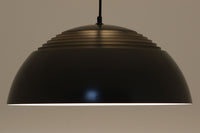 アルネ・ヤコブセンによってデザインされ、Louis Poulsen(ルイスポールセン)より製造されたAJロイヤル ペンダントライト。こちらは希少なグラファイトグレーカラーで、落ち着いたトーンが空間にシックな雰囲気を演出します。直径50cmの大型サイズで、光源を遮る構造と放射状に配置されたルーバーにより、眩しさを抑えた柔らかい光が空間全体を包み込みます。点灯時には上部のスリットから漏れる光も美しく、デザイン性と機能性を兼ね備えた一品です。外観には小傷や使用感がありますが、ビンテージならではの風合いとしてお楽しみいただけます。