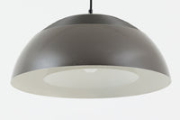 アルネ・ヤコブセンによってデザインされ、Louis Poulsen(ルイスポールセン)より製造されたAJロイヤル ペンダントライト。こちらは希少なグラファイトグレーカラーで、落ち着いたトーンが空間にシックな雰囲気を演出します。直径50cmの大型サイズで、光源を遮る構造と放射状に配置されたルーバーにより、眩しさを抑えた柔らかい光が空間全体を包み込みます。点灯時には上部のスリットから漏れる光も美しく、デザイン性と機能性を兼ね備えた一品です。外観には小傷や使用感がありますが、ビンテージならではの風合いとしてお楽しみいただけます。