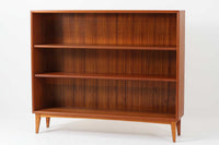 スウェーデン製のビンテージブックシェルフ。本体にはチーク材、脚部と幕板にはビーチ材を使用し、素材のコントラストが柔らかで落ち着いた印象を与えます。直線的でシンプルなフォルムながら、ジョイント部の細かい造りが視覚的なアクセントとなっており、程よい存在感を持っています。奥行き27cmと薄型ながら収納力に優れ、書籍や雑貨、コレクションのディスプレイにも最適です。リビングや書斎はもちろん、寝室など様々なシーンで活用できる一台です。