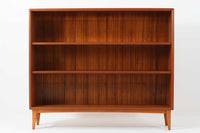 スウェーデン製のビンテージブックシェルフ。本体にはチーク材、脚部と幕板にはビーチ材を使用し、素材のコントラストが柔らかで落ち着いた印象を与えます。直線的でシンプルなフォルムながら、ジョイント部の細かい造りが視覚的なアクセントとなっており、程よい存在感を持っています。奥行き27cmと薄型ながら収納力に優れ、書籍や雑貨、コレクションのディスプレイにも最適です。リビングや書斎はもちろん、寝室など様々なシーンで活用できる一台です。