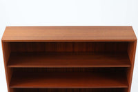 スウェーデン製のビンテージブックシェルフ。本体にはチーク材、脚部と幕板にはビーチ材を使用し、素材のコントラストが柔らかで落ち着いた印象を与えます。直線的でシンプルなフォルムながら、ジョイント部の細かい造りが視覚的なアクセントとなっており、程よい存在感を持っています。奥行き27cmと薄型ながら収納力に優れ、書籍や雑貨、コレクションのディスプレイにも最適です。リビングや書斎はもちろん、寝室など様々なシーンで活用できる一台です。