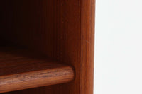 スウェーデン製のビンテージブックシェルフ。本体にはチーク材、脚部と幕板にはビーチ材を使用し、素材のコントラストが柔らかで落ち着いた印象を与えます。直線的でシンプルなフォルムながら、ジョイント部の細かい造りが視覚的なアクセントとなっており、程よい存在感を持っています。奥行き27cmと薄型ながら収納力に優れ、書籍や雑貨、コレクションのディスプレイにも最適です。リビングや書斎はもちろん、寝室など様々なシーンで活用できる一台です。