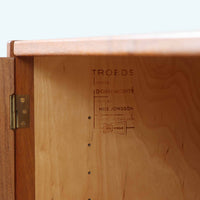 Nils JonssonがTroeds社のためにデザインした「Domi Monté」モデルのディスプレイシェルフ。チーク材を贅沢に使用し、温かみのある木肌と洗練されたフォルムが魅力の一台です。上部には高さ調整が可能な可動棚が8枚備わり、本やオブジェのディスプレイに柔軟に対応。下部には扉付き収納と仕切り付きの引き出しが配されており、実用性にも優れます。背面にはTroeds社の刻印が残されており、スウェーデン製ビンテージ家具としての確かな出自を物語ります。空間に落ち着きと上質な雰囲気を添える、北欧モダンらしい逸品です。