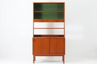 スウェーデンの老舗家具メーカーBodafors社によって製造されたヴィンテージのディスプレイシェルフ。デザインを手がけたのはスウェーデンのデザイナー、Bertil Fridhagen。上部はスライド式のガラス扉と引き出し収納を備え、下部にはチーク材のスライド扉を組み合わせた実用性の高い構成です。グリーンの背板がアクセントとなり、飾るものを引き立てながら、空間に柔らかな彩りを添えます。細部のディテールにも北欧らしい丁寧な作り込みが感じられ、使い勝手と美しさが調和した一台。リビングでのディスプレイ収納としてはもちろん、食器棚や書棚など多目的に活躍します。