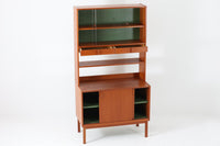 スウェーデンの老舗家具メーカーBodafors社によって製造されたヴィンテージのディスプレイシェルフ。デザインを手がけたのはスウェーデンのデザイナー、Bertil Fridhagen。上部はスライド式のガラス扉と引き出し収納を備え、下部にはチーク材のスライド扉を組み合わせた実用性の高い構成です。グリーンの背板がアクセントとなり、飾るものを引き立てながら、空間に柔らかな彩りを添えます。細部のディテールにも北欧らしい丁寧な作り込みが感じられ、使い勝手と美しさが調和した一台。リビングでのディスプレイ収納としてはもちろん、食器棚や書棚など多目的に活躍します。