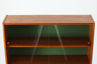 スウェーデンの老舗家具メーカーBodafors社によって製造されたヴィンテージのディスプレイシェルフ。デザインを手がけたのはスウェーデンのデザイナー、Bertil Fridhagen。上部はスライド式のガラス扉と引き出し収納を備え、下部にはチーク材のスライド扉を組み合わせた実用性の高い構成です。グリーンの背板がアクセントとなり、飾るものを引き立てながら、空間に柔らかな彩りを添えます。細部のディテールにも北欧らしい丁寧な作り込みが感じられ、使い勝手と美しさが調和した一台。リビングでのディスプレイ収納としてはもちろん、食器棚や書棚など多目的に活躍します。