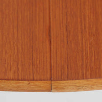 チーク材の天板とオーク材の脚部が美しく調和したこちらの円形エクステンションダイニングテーブルは、デンマーク製ならではの丁寧な仕上げと実用性が魅力の北欧ビンテージ家具です。直径110cmの円形天板は、中央に拡張板を2枚追加することで広々としたオーバル型に変化し、来客時やホームパーティーなどにも柔軟に対応できます。細身のテーパー脚が軽やかな印象を与え、温かみのある木の表情が空間に自然と溶け込む逸品です。