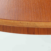 チーク材の天板とオーク材の脚部が美しく調和したこちらの円形エクステンションダイニングテーブルは、デンマーク製ならではの丁寧な仕上げと実用性が魅力の北欧ビンテージ家具です。直径110cmの円形天板は、中央に拡張板を2枚追加することで広々としたオーバル型に変化し、来客時やホームパーティーなどにも柔軟に対応できます。細身のテーパー脚が軽やかな印象を与え、温かみのある木の表情が空間に自然と溶け込む逸品です。