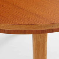 チーク材の天板とオーク材の脚部が美しく調和したこちらの円形エクステンションダイニングテーブルは、デンマーク製ならではの丁寧な仕上げと実用性が魅力の北欧ビンテージ家具です。直径110cmの円形天板は、中央に拡張板を2枚追加することで広々としたオーバル型に変化し、来客時やホームパーティーなどにも柔軟に対応できます。細身のテーパー脚が軽やかな印象を与え、温かみのある木の表情が空間に自然と溶け込む逸品です。