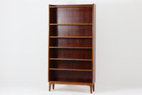 スウェーデンで製造されたヴィンテージのブックシェルフ。本体には深みのある美しいマホガニー材を使用し、縁や脚部にはナチュラルな風合いのビーチ材を組み合わせた、上品で洗練されたデザインが魅力です。特徴的なのは、上から下に向かって奥行が深くなる構造。視覚的な軽やかさを保ちながらも収納力を確保し、機能性とデザイン性を両立した作りになっています。脚部の緩やかな曲線が北欧家具らしいエレガントな印象を与え、インテリアに品のある温かみをプラスしてくれます。書籍やディスプレイアイテムを美しく収納できる、実用性とデザイン性を兼ね備えた一品。シンプルながらもこだわりを感じさせる北欧ヴィンテージ家具をお探しの方におすすめです。