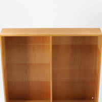 Borge Mogensenがデザインし、Karl Andersson社により製造されたこちらのディスプレイシェルフは、チーク材とオーク材のコントラストが美しいスウェーデン製の北欧ビンテージ家具です。上部はオープン構造で5段の棚が左右に配されており、書籍や器、小物のディスプレイに最適で、下部にはスライド扉収納も備え実用性にも優れています。幅135cmと存在感のあるサイズながら、直線的で端正な佇まいが空間に凛とした印象を与える一台です。