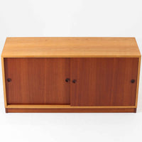 Borge Mogensenがデザインし、Karl Andersson社により製造されたこちらのディスプレイシェルフは、チーク材とオーク材のコントラストが美しいスウェーデン製の北欧ビンテージ家具です。上部はオープン構造で5段の棚が左右に配されており、書籍や器、小物のディスプレイに最適で、下部にはスライド扉収納も備え実用性にも優れています。幅135cmと存在感のあるサイズながら、直線的で端正な佇まいが空間に凛とした印象を与える一台です。