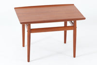 デンマークの女性デザイナー、グレーテ・ヤルクがデザインした1960年代のサイドテーブルです。Glostrup mobelfabrik社の製作による北欧モダンを代表する名作となっています。チーク材を贅沢に使用し、天板の緩やかな曲線と細身の脚部が美しいバランスを生み出しています。中段の横桟は、デザイン性と構造的な強度を両立。脚部は緩やかに外向きに設置され、安定感とエレガントさを兼ね備えています。コンパクトなサイズ感で、ソファサイドやベッドサイドなど様々な場所で活躍。現代のインテリアにも自然に溶け込む、時代を超えた普遍的なデザインの逸品です。