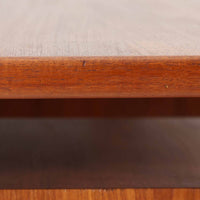 カイ・クリスチャンセンがデザインし、FM furniture社によって製造されたこちらの両袖デスクは、チーク材の美しい木目と温かみのある色合いが魅力の北欧ビンテージ家具です。左右には3杯ずつの引き出し、中央には扉付き収納を備え、背面にはオープンシェルフが設けられており、デスクとしての高い収納力と機能性を誇ります。壁付けはもちろん、間仕切りとしても活用できるため、空間の中心にも映える設計です。丸みを帯びた取手や脚部など、細部にまでこだわった意匠は、カイ・クリスチャンセンらしい洗練された美しさを体現しており、上質なワークスペースを演出します。