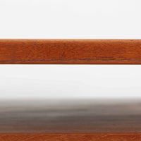 カイ・クリスチャンセンがデザインし、FM furniture社によって製造されたこちらの両袖デスクは、チーク材の美しい木目と温かみのある色合いが魅力の北欧ビンテージ家具です。左右には3杯ずつの引き出し、中央には扉付き収納を備え、背面にはオープンシェルフが設けられており、デスクとしての高い収納力と機能性を誇ります。壁付けはもちろん、間仕切りとしても活用できるため、空間の中心にも映える設計です。丸みを帯びた取手や脚部など、細部にまでこだわった意匠は、カイ・クリスチャンセンらしい洗練された美しさを体現しており、上質なワークスペースを演出します。