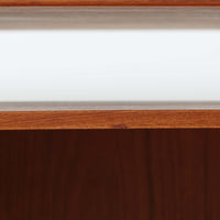 カイ・クリスチャンセンがデザインし、FM furniture社によって製造されたこちらの両袖デスクは、チーク材の美しい木目と温かみのある色合いが魅力の北欧ビンテージ家具です。左右には3杯ずつの引き出し、中央には扉付き収納を備え、背面にはオープンシェルフが設けられており、デスクとしての高い収納力と機能性を誇ります。壁付けはもちろん、間仕切りとしても活用できるため、空間の中心にも映える設計です。丸みを帯びた取手や脚部など、細部にまでこだわった意匠は、カイ・クリスチャンセンらしい洗練された美しさを体現しており、上質なワークスペースを演出します。