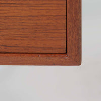 カイ・クリスチャンセンがデザインし、FM furniture社によって製造されたこちらの両袖デスクは、チーク材の美しい木目と温かみのある色合いが魅力の北欧ビンテージ家具です。左右には3杯ずつの引き出し、中央には扉付き収納を備え、背面にはオープンシェルフが設けられており、デスクとしての高い収納力と機能性を誇ります。壁付けはもちろん、間仕切りとしても活用できるため、空間の中心にも映える設計です。丸みを帯びた取手や脚部など、細部にまでこだわった意匠は、カイ・クリスチャンセンらしい洗練された美しさを体現しており、上質なワークスペースを演出します。