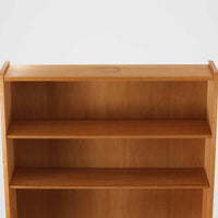 Johannes Sorthがデザインし、Bornholms Mobelfabrik社から1965年に製造されたこちらのブックシェルフは、美しい木目のオーク材と縦長のすっきりとしたフォルムが印象的な北欧ビンテージ家具で、豊富な棚板が本や雑貨の収納に優れた実用性を発揮します。裏面には「29 JUNI 1965」の刻印が残されており、当時のクラフトマンシップを感じさせる趣深い一台です。