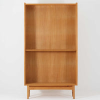 Johannes Sorthがデザインし、Bornholms Mobelfabrik社から1965年に製造されたこちらのブックシェルフは、美しい木目のオーク材と縦長のすっきりとしたフォルムが印象的な北欧ビンテージ家具で、豊富な棚板が本や雑貨の収納に優れた実用性を発揮します。裏面には「29 JUNI 1965」の刻印が残されており、当時のクラフトマンシップを感じさせる趣深い一台です。