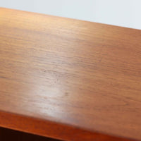 Poul Hundevadがデザインし、Hundevad & Co社によって製造されたこちらの大型ブックシェルフは、幅139cmの堂々としたサイズと美しいチーク材の木目が印象的な北欧ビンテージ家具です。12段の棚構成により書籍やコレクションの収納に優れ、棚板は取り外し可能で用途に応じた柔軟なレイアウトが可能です。背面にはDanish ControlとHundevadの刻印が残されており、デザイン性と品質の高さを物語る一台です。シンプルながらも洗練された佇まいは、リビングや書斎の主役としても存在感を放ちます。