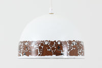 フィンランドの名窯ARABIA(アラビア)社によるRITARI(リタリ)シリーズのビンテージランプシェードです。柔らかなカーブを描くドーム型のフォルムは、フィンランドモダンを代表するデザイナーKaj Franck(カイ・フランク)によるもので、花と人物が描かれた印象的な装飾はRaija Uosikkinen(ライヤ・ウオシッキネン)によってデザインされました。RITARIはフィンランド語で「騎士」を意味し、中世の衣装をまとった人物たちが、ブラウンを基調とした花々とともにシェードをぐるりと囲むユニークでノスタルジックなデザインが特徴です。素材はホーロー(琺瑯)製で、しっかりとした重量感と経年による独特の風合いも楽しめるアイテム。点灯時にはやわらかな光を下方向に届け、空間に温もりを添えてくれます。北欧らしいストーリー性とデザイン性を併せ持った、希少なビンテージ照明をお探しの方におすすめです。