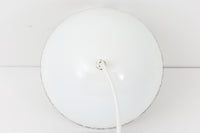 フィンランドの名窯ARABIA(アラビア)社によるRITARI(リタリ)シリーズのビンテージランプシェードです。柔らかなカーブを描くドーム型のフォルムは、フィンランドモダンを代表するデザイナーKaj Franck(カイ・フランク)によるもので、花と人物が描かれた印象的な装飾はRaija Uosikkinen(ライヤ・ウオシッキネン)によってデザインされました。RITARIはフィンランド語で「騎士」を意味し、中世の衣装をまとった人物たちが、ブラウンを基調とした花々とともにシェードをぐるりと囲むユニークでノスタルジックなデザインが特徴です。素材はホーロー(琺瑯)製で、しっかりとした重量感と経年による独特の風合いも楽しめるアイテム。点灯時にはやわらかな光を下方向に届け、空間に温もりを添えてくれます。北欧らしいストーリー性とデザイン性を併せ持った、希少なビンテージ照明をお探しの方におすすめです。