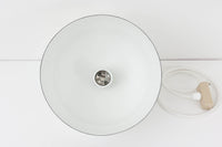 フィンランドの名窯ARABIA(アラビア)社によるRITARI(リタリ)シリーズのビンテージランプシェードです。柔らかなカーブを描くドーム型のフォルムは、フィンランドモダンを代表するデザイナーKaj Franck(カイ・フランク)によるもので、花と人物が描かれた印象的な装飾はRaija Uosikkinen(ライヤ・ウオシッキネン)によってデザインされました。RITARIはフィンランド語で「騎士」を意味し、中世の衣装をまとった人物たちが、ブラウンを基調とした花々とともにシェードをぐるりと囲むユニークでノスタルジックなデザインが特徴です。素材はホーロー(琺瑯)製で、しっかりとした重量感と経年による独特の風合いも楽しめるアイテム。点灯時にはやわらかな光を下方向に届け、空間に温もりを添えてくれます。北欧らしいストーリー性とデザイン性を併せ持った、希少なビンテージ照明をお探しの方におすすめです。