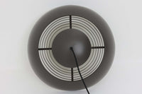 アルネ・ヤコブセンによってデザインされ、Louis Poulsen(ルイスポールセン)より製造されたAJロイヤル ペンダントライト。こちらは希少なグラファイトグレーカラーで、落ち着いたトーンが空間にシックな雰囲気を演出します。直径50cmの大型サイズで、光源を遮る構造と放射状に配置されたルーバーにより、眩しさを抑えた柔らかい光が空間全体を包み込みます。点灯時には上部のスリットから漏れる光も美しく、デザイン性と機能性を兼ね備えた一品です。外観には小傷や使用感がありますが、ビンテージならではの風合いとしてお楽しみいただけます。