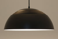 アルネ・ヤコブセンによってデザインされ、Louis Poulsen(ルイスポールセン)より製造されたAJロイヤル ペンダントライト。こちらは希少なグラファイトグレーカラーで、落ち着いたトーンが空間にシックな雰囲気を演出します。直径50cmの大型サイズで、光源を遮る構造と放射状に配置されたルーバーにより、眩しさを抑えた柔らかい光が空間全体を包み込みます。点灯時には上部のスリットから漏れる光も美しく、デザイン性と機能性を兼ね備えた一品です。外観には小傷や使用感がありますが、ビンテージならではの風合いとしてお楽しみいただけます。