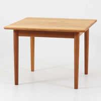 Hans J. WegnerがデザインしGetama社より製造されたGE80/86センターテーブルは、オーク無垢材を贅沢に使用した堅牢かつ端正な一台です。丸みを帯びた天板の縁や、すっきりとした円錐形の脚部が特徴で、シンプルでありながら温かみのある北欧デザインを体現しています。幅75cmと扱いやすいサイズ感で、リビングの中心に置いてコーヒーテーブルとしてはもちろん、サイドに添えても活躍する汎用性の高い家具です。経年による木肌の変化が深みを増し、ビンテージならではの存在感を放ちます。