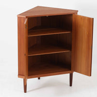 三角形のユニークなフォルムが目を引くこちらのコーナーキャビネットは、デンマーク製の北欧ビンテージ家具です。チーク材の温もりある木肌と、鍵付きのシンメトリーな扉が上品な佇まいを演出します。内部には棚板が2枚設けられており、日用品や雑貨などの収納に実用的。空間の角にすっきりと収まる設計は、デッドスペースを活かしながら、インテリアに程よいアクセントを加えてくれます。シンプルながら希少性を感じさせる一台です。