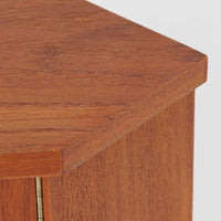 三角形のユニークなフォルムが目を引くこちらのコーナーキャビネットは、デンマーク製の北欧ビンテージ家具です。チーク材の温もりある木肌と、鍵付きのシンメトリーな扉が上品な佇まいを演出します。内部には棚板が2枚設けられており、日用品や雑貨などの収納に実用的。空間の角にすっきりと収まる設計は、デッドスペースを活かしながら、インテリアに程よいアクセントを加えてくれます。シンプルながら希少性を感じさせる一台です。