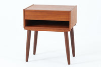 デンマークで製造されたヴィンテージのサイドチェスト。温もりのあるチーク材を用いた本体に、先細りの丸脚を組み合わせた軽やかな佇まいが魅力です。引き出し1杯に加え、下部にはオープンスペースを備えており、リモコンや文庫本などをすぐに取り出せる実用的な構造。天板や側面にはすっきりとした面取りが施され、シンプルなデザインの中に丁寧な仕事が感じられます。北欧らしいあたたかみと実用性を兼ね備えた一台。ベッドサイドはもちろん、リビングや玄関先など、暮らしのさまざまな場面で活躍します。