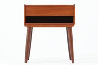 デンマークで製造されたヴィンテージのサイドチェスト。温もりのあるチーク材を用いた本体に、先細りの丸脚を組み合わせた軽やかな佇まいが魅力です。引き出し1杯に加え、下部にはオープンスペースを備えており、リモコンや文庫本などをすぐに取り出せる実用的な構造。天板や側面にはすっきりとした面取りが施され、シンプルなデザインの中に丁寧な仕事が感じられます。北欧らしいあたたかみと実用性を兼ね備えた一台。ベッドサイドはもちろん、リビングや玄関先など、暮らしのさまざまな場面で活躍します。