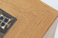 デンマークの家具デザイナー、Severin Hansen Jr.によってデザインされたビンテージのサイドテーブルです。製造はデンマークの名門家具メーカー「Haslev(ハスレヴ)」社。天板にはRoyal Copenhagen(ロイヤルコペンハーゲン)のアートタイルが贅沢にあしらわれています。タイルはNils Thorsson(ニルス・トーソン)が手掛けた人気の「BACA(バッカ)」シリーズ。象徴的なブルーとブラウンの色使いと、有機的かつ幾何学的なモチーフが印象的で、アートピースとしての存在感を放ちます。テーブル本体はオーク材を使用しており、Severin Hansen Jr.の特徴でもあるシャープなカットが施されたコーナーと、すっきりとしたテーパードレッグが、シンプルながら洗練された美しさを醸し出しています。ヴィンテージならではの深い味わいと、アート性・機能性を兼ね備えた一台。リビングやベッドサイドに、さりげなく上質な北欧デザインを取り入れてみてはいかがでしょうか。