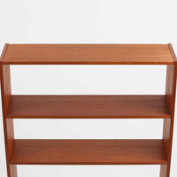 スウェーデンのBreox Mobler社製によるチーク材オープンシェルフで、幅85cmと使いやすいサイズ感の北欧ビンテージ家具です。上部は3段のオープン棚で書籍やオブジェを美しく飾ることができ、下部には鍵付き扉の収納スペースを備えており、実用性とデザイン性を兼ね備えています。直線的で軽やかなフレーム構造が北欧らしいシンプルな美を感じさせ、経年によるチーク材の深みある色合いがさらに存在感を高めています。リビングや書斎の収納兼ディスプレイとして最適な一台です。