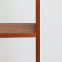 スウェーデンのBreox Mobler社製によるチーク材オープンシェルフで、幅85cmと使いやすいサイズ感の北欧ビンテージ家具です。上部は3段のオープン棚で書籍やオブジェを美しく飾ることができ、下部には鍵付き扉の収納スペースを備えており、実用性とデザイン性を兼ね備えています。直線的で軽やかなフレーム構造が北欧らしいシンプルな美を感じさせ、経年によるチーク材の深みある色合いがさらに存在感を高めています。リビングや書斎の収納兼ディスプレイとして最適な一台です。