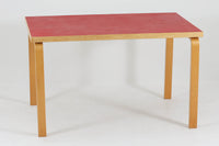 Artek社による、Alvar Aaltoデザインの幅120cmのダイニングテーブル。1970~1980年代に製造されたと考えられるヴィンテージ品です。Aaltoらしい流れるような曲線と、機能美を兼ね備えたデザインが特徴的。天板にはリノリウムが施されており、落ち着いたマットな質感と耐久性を備えています。温かみのあるバーチ材のフレームと、鮮やかなレッドの天板が美しいコントラストを生み出し、空間に独特の存在感を与えます。シンプルでありながら洗練された佇まいは、北欧デザインの魅力を存分に感じさせる一台です。