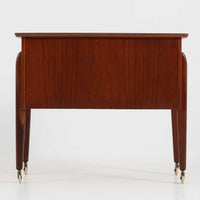 チーク材を使用したデンマーク製のソーイングテーブルです。丸みを帯びた脚部と有機的な取っ手のデザインが愛らしく、温かみのある木目が上品な印象を与えます。引き出し内には仕切りが設けられ、小物の整理にも便利。キャスター付きで移動もスムーズに行えます。ミシン台や裁縫用としてはもちろん、リビングでサイドテーブルや収納台としても活躍する汎用性の高い一台です。経年によるチークの深い色艶が、北欧ビンテージ家具ならではの趣を添えています。