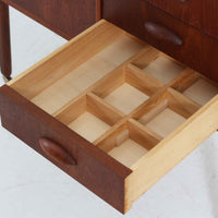 チーク材を使用したデンマーク製のソーイングテーブルです。丸みを帯びた脚部と有機的な取っ手のデザインが愛らしく、温かみのある木目が上品な印象を与えます。引き出し内には仕切りが設けられ、小物の整理にも便利。キャスター付きで移動もスムーズに行えます。ミシン台や裁縫用としてはもちろん、リビングでサイドテーブルや収納台としても活躍する汎用性の高い一台です。経年によるチークの深い色艶が、北欧ビンテージ家具ならではの趣を添えています。