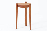 デンマーク製のビンテージ3本脚サイドテーブルです。天板・脚部ともにチーク無垢材を使用しており、木の質感を存分に楽しめる一品です。円形の天板に3本の丸脚を配したシンプルなデザインながら、脚の先端が天板を貫通して突き出した構造がアクセントとなり、クラフト感のある佇まいを演出しています。花台やソファ横のテーブルとしてなど、空間のポイントになる小家具としておすすめです。幅24cm×奥行24.5cmとコンパクトなサイズ感で、日本の住空間にも取り入れやすいアイテムです。