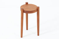 デンマーク製のビンテージ3本脚サイドテーブルです。天板・脚部ともにチーク無垢材を使用しており、木の質感を存分に楽しめる一品です。円形の天板に3本の丸脚を配したシンプルなデザインながら、脚の先端が天板を貫通して突き出した構造がアクセントとなり、クラフト感のある佇まいを演出しています。花台やソファ横のテーブルとしてなど、空間のポイントになる小家具としておすすめです。幅24cm×奥行24.5cmとコンパクトなサイズ感で、日本の住空間にも取り入れやすいアイテムです。