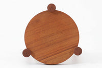 デンマーク製のビンテージ3本脚サイドテーブルです。天板・脚部ともにチーク無垢材を使用しており、木の質感を存分に楽しめる一品です。円形の天板に3本の丸脚を配したシンプルなデザインながら、脚の先端が天板を貫通して突き出した構造がアクセントとなり、クラフト感のある佇まいを演出しています。花台やソファ横のテーブルとしてなど、空間のポイントになる小家具としておすすめです。幅24cm×奥行24.5cmとコンパクトなサイズ感で、日本の住空間にも取り入れやすいアイテムです。