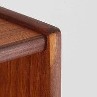 チーク材の温もりが魅力のこちらのディスプレイシェルフは、引き出し収納と棚が一体となった北欧ビンテージらしい実用性と美しさを兼ね備えた一台で、下段には鍵付きの3杯引き出し、上段には棚が3段設けられており、書斎やリビングの収納兼飾り棚としてはもちろん、店舗什器としても活躍します。細身の丸脚が全体に軽やかな印象を与え、チーク材特有の深みのある色合いと経年による艶が上質な雰囲気を醸し出しています。