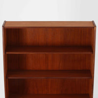 チーク材の温もりが魅力のこちらのディスプレイシェルフは、引き出し収納と棚が一体となった北欧ビンテージらしい実用性と美しさを兼ね備えた一台で、下段には鍵付きの3杯引き出し、上段には棚が3段設けられており、書斎やリビングの収納兼飾り棚としてはもちろん、店舗什器としても活躍します。細身の丸脚が全体に軽やかな印象を与え、チーク材特有の深みのある色合いと経年による艶が上質な雰囲気を醸し出しています。